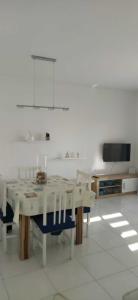 Habitación blanca con mesa con sillas y TV. en Apartamento a 50m de la playa - Ideal familia, en Miami Platja