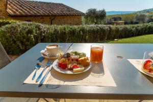 a plate of food on a table with a drink at Borgo Canalicchio Di Sopra Relais in Montalcino