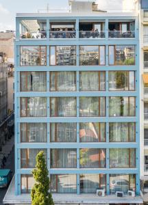 an office building with large windows with people on the balcony at Zeus is Loose Hostel in Thessaloniki