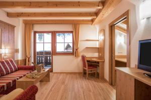 een woonkamer met een bank en een tv bij Apartment Pürstal - Gruberhof in San Giacomo