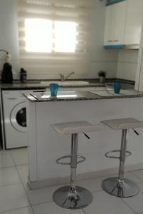 cocina con barra y 2 taburetes en Apartamento a 50m de la playa - Ideal familia, en Miami Platja