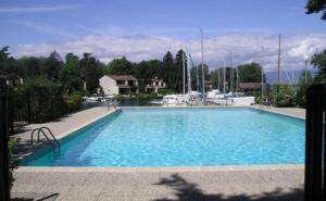 a large blue swimming pool with boats in the water at Port Ripaille, les grèbes 24 in Thonon-les-Bains