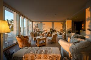 a living room with couches and chairs and a large window at Stellamare in Caorle +37 photos