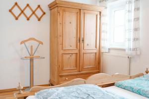 a bedroom with a wooden cabinet next to a bed at Weingut Leopold Dietrich in Gamlitz