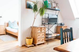 a living room with a tv and a potted plant at Weingut Leopold Dietrich in Gamlitz