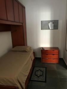 um quarto com uma cama e uma cómoda em madeira em Casa Aconchego em Itu