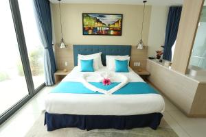 um quarto de hotel com uma cama com um coração feito de toalhas em Oceanami Resort em Long Hai