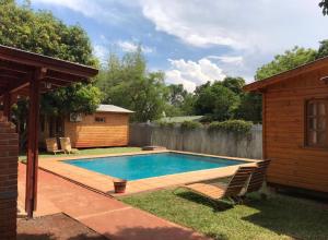 a swimming pool in a yard next to a house at BUGANVILIAS LODGE in Puerto Iguazú