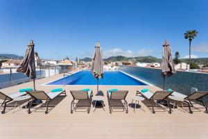 un grupo de sillas y sombrillas junto a una piscina en La Laguna Gran Hotel en La Laguna