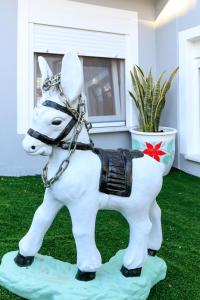 Una statua di un cavallo bianco sull'erba di Loridis View Apartments a Prinos