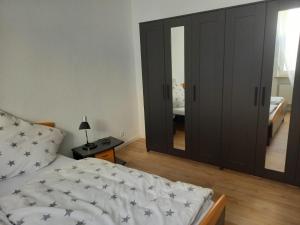ein Schlafzimmer mit einem Bett und einem großen Spiegel in der Unterkunft Falkennest-lu in Ludwigshafen am Rhein