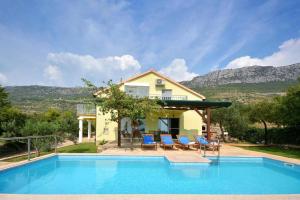 Villa con piscina frente a una casa en Holiday Home Nevenka en Kaštela