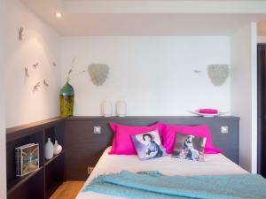 a bedroom with pink and blue pillows on a bed at Le Clos Du Lac - location de chambres in Veyrier-du-Lac