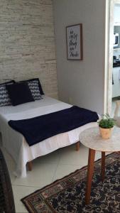 a bedroom with a bed and a table in it at MARCOLINI - Praia Rio - Barra da Tijuca in Rio de Janeiro