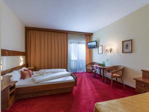 ein Hotelzimmer mit einem Bett und einem Tisch in der Unterkunft Pension Elisabeth in Westendorf + 37 Fotos