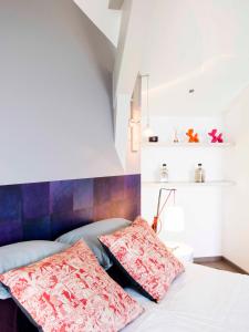 a bedroom with a bed with two pillows on it at Le Clos Du Lac - location de chambres in Veyrier-du-Lac