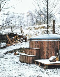 einen schneebedeckten Hof mit einem Holzzaun und einer Bank in der Unterkunft LushHills - Tiny House - Modern House On Wheels in Regulice