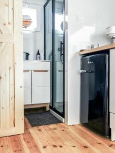 een keuken met een glazen douche en een koelkast bij LushHills - Tiny House - Modern House On Wheels in Regulice