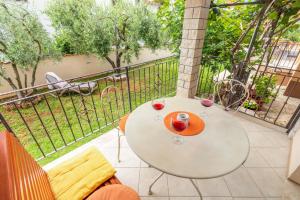 a table with two glasses of wine on a balcony at Apartments Nono in Poreč