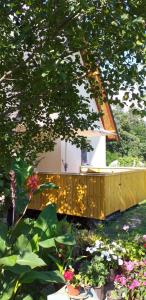 mały domek z drewnianym tarasem w ogrodzie w obiekcie Vikendica na Jazu w mieście Kosjeric