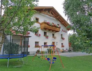 una casa con un parque infantil delante de ella en Haus zur Mühle, en Ried im Oberinntal
