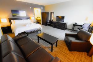 a hotel room with a bed and a couch and chairs at Canad Inns Health Sciences Centre in Winnipeg