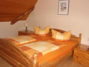 ein Schlafzimmer mit einem großen Holzbett mit Kissen in der Unterkunft Ferienwohnung Neureuth in Schillingsfürst