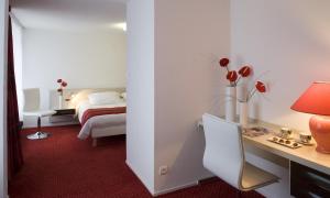a hotel room with a bed and a desk and a bedroom at Gran Carlina Hotel in Le Mont-Dore