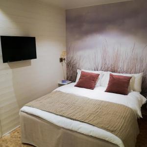 a bedroom with a large bed and a flat screen tv at Skäftekärr Hotell och Konferens in Löttorp
