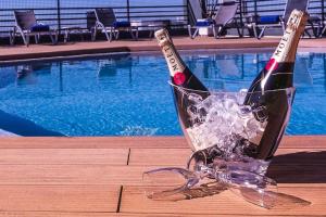 two bottles of wine in a ice bucket next to a swimming pool at Holiday Inn Lisbon by IHG in Lisbon