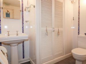 a bathroom with a shower and a toilet and a sink at Hawthorn Cottage in Bodmin +17 photos