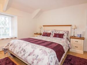 a bedroom with a large bed and two night stands at Hawthorn Cottage in Bodmin