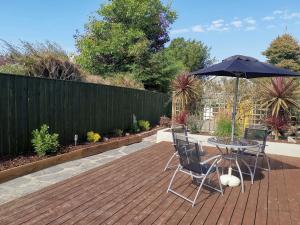 a patio with a table and an umbrella at Hawthorn Cottage in Bodmin
