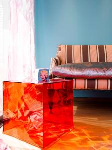 a red glass coffee table in front of a couch at Le Clos Du Lac - location de chambres in Veyrier-du-Lac