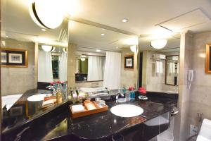 a bathroom with two sinks and a large mirror at Grand China Bangkok in Bangkok