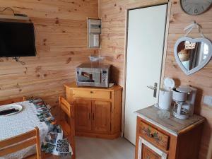 Cette chambre dispose d'une télévision et d'un mur en bois. dans l'établissement Appartement Combes Blanche 2, à Manigod