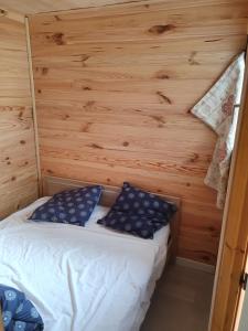 Ce petit lit se trouve dans un dortoir doté de murs en bois. dans l'établissement Appartement Combes Blanche 2, à Manigod