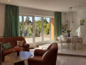 a living room with two couches and a table and a dining room at Dália Ház in Velence