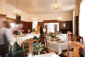 una sala da pranzo con tavoli con tovaglie bianche di Hotel Stadt Hannover a Gottinga