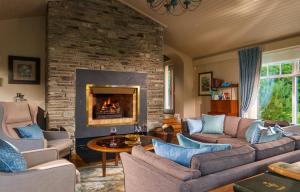 a living room with a couch and a fireplace at Sheen Falls Lodge in Kenmare