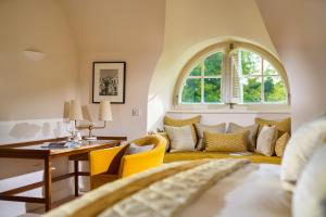 a bedroom with a bed and a desk and a window at Sheen Falls Lodge in Kenmare