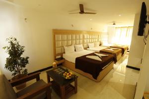 a hotel room with two beds and a table at New Cape Hotel in Kanyakumari