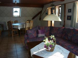 ein Wohnzimmer mit einem Sofa und einem Tisch in der Unterkunft Ferienwohnung Neureuth in Schillingsfürst