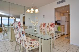 uma cozinha com uma mesa de vidro e cadeiras em Our House at the Beach 501W em Siesta Key