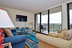a living room with blue furniture and a balcony at Our House at the Beach; by Beachside Management in Siesta Key