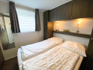 a bedroom with two beds and a window at Vakantiechalet Serooskerke SE04 in Serooskerke