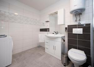 a white bathroom with a toilet and a sink at Apartment Piccolo Paradiso in Split