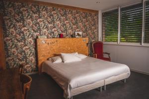 una camera con un letto in una stanza con carta da parati floreale di Le Jardin de la Reyssouze a Gorrevod