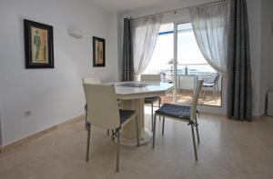 una sala da pranzo con tavolo, sedie e finestra di Apartment SUNRISE a Estepona
