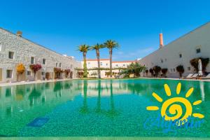 a swimming pool in a building with a sun painted on it at Convento das Bernardas By Algartur in Tavira